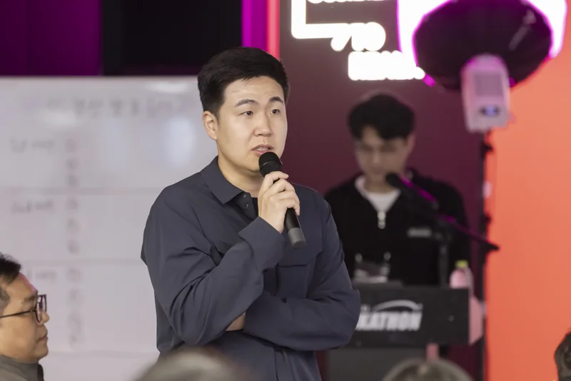 행사장에서 마이크를 들고 인사하는 모습