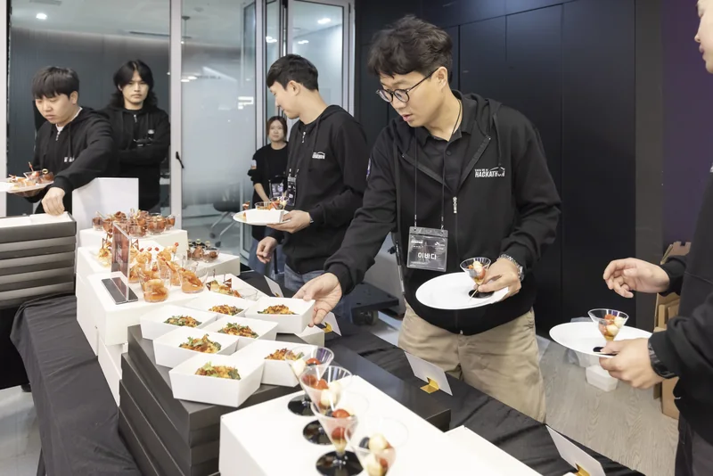 다과 테이블에서 음식을 담는 참가자들